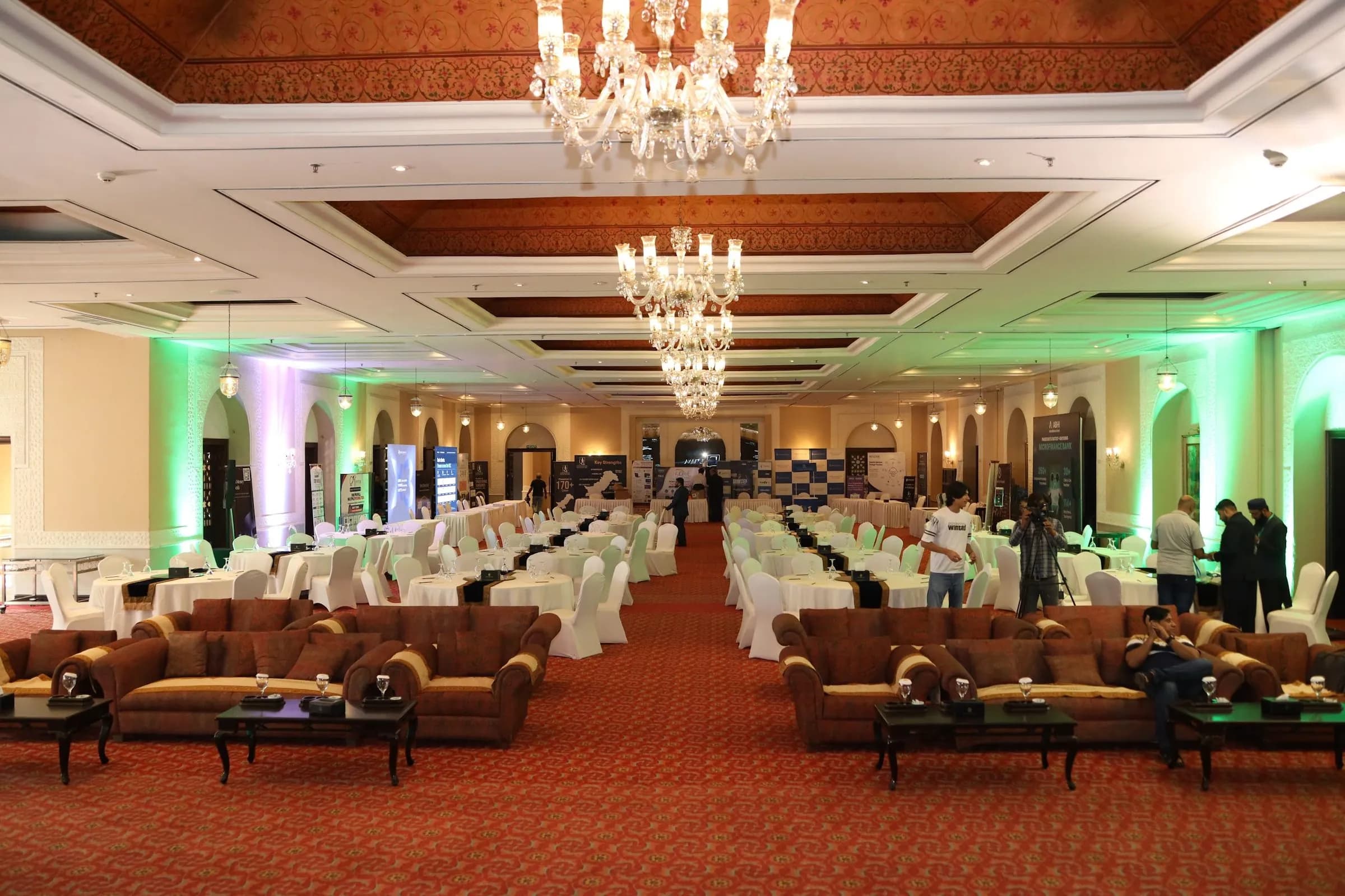 The ballroom set with chandeliers, lounge seating and green lighting before doors opened at PBLS Serena Islamabad