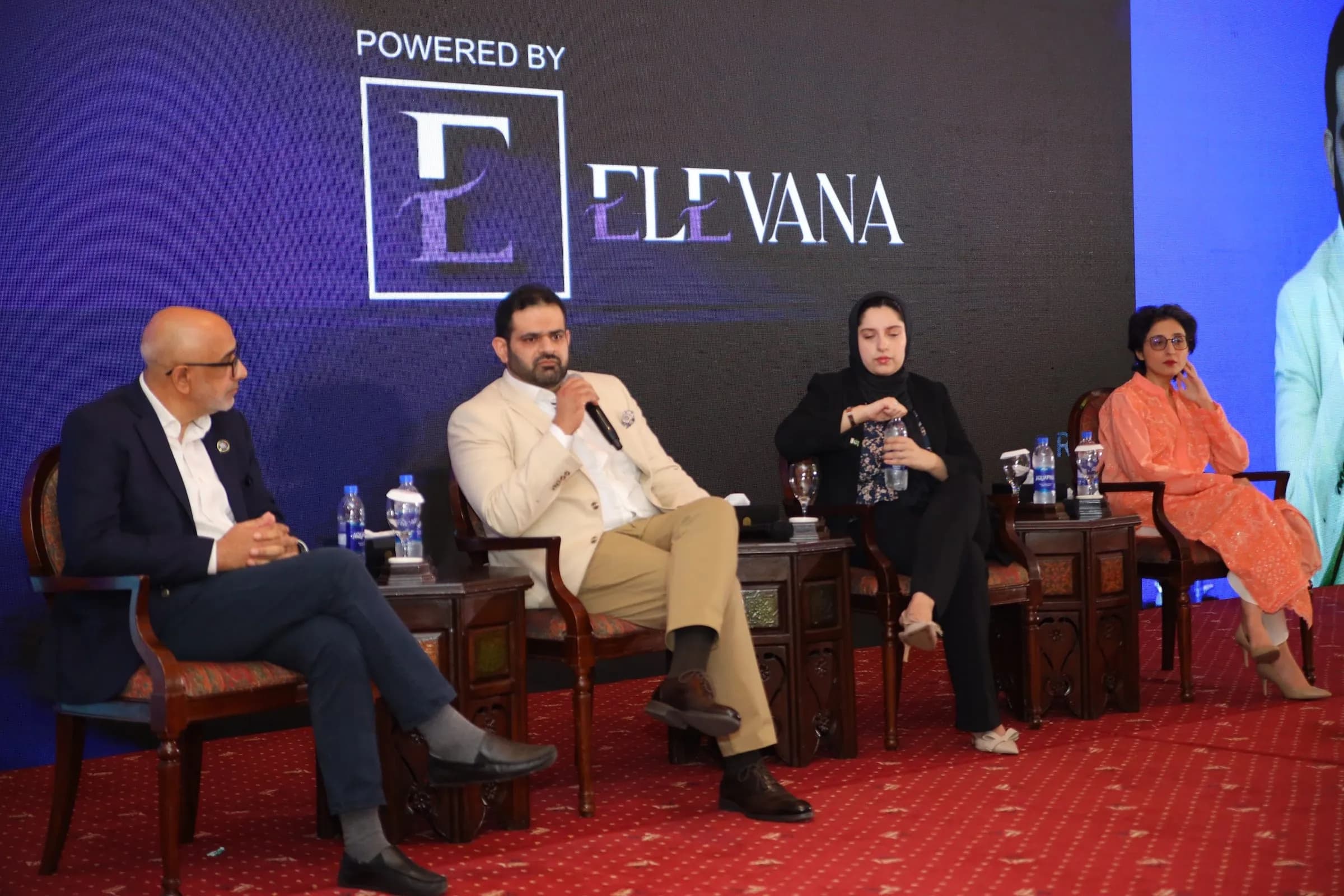 Four panelists in conversation on stage in front of the Elevana backdrop at PBLS Serena Islamabad