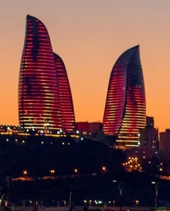 The Flame Towers lit red against the dusk sky
